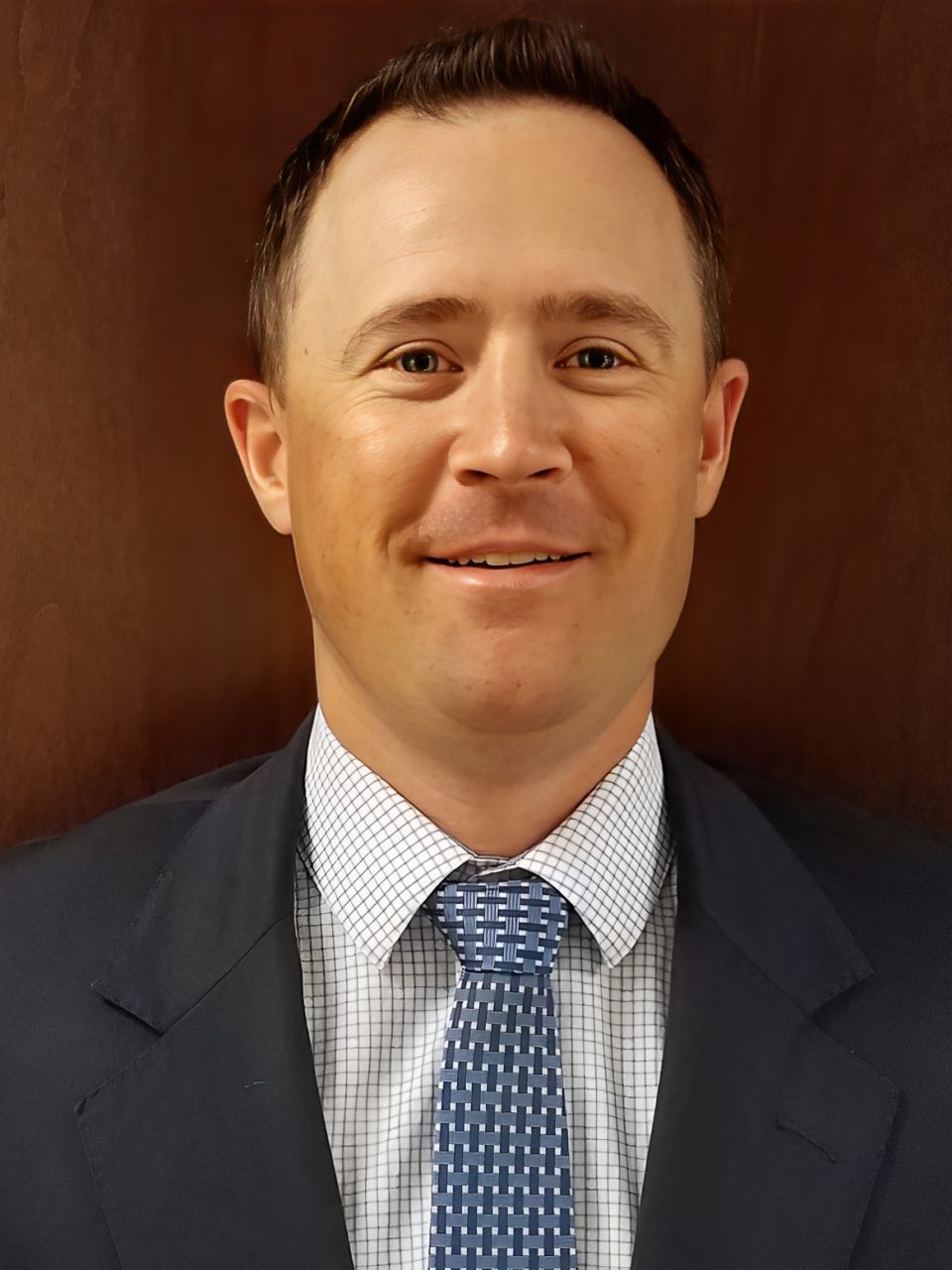 Man in suit with blue patterned tie.