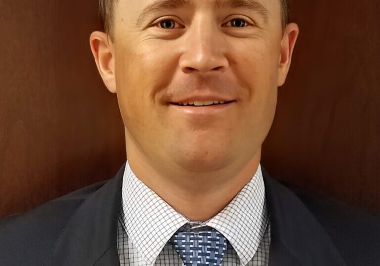 Man in suit with blue patterned tie.