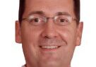 Smiling person wearing glasses and a shirt.